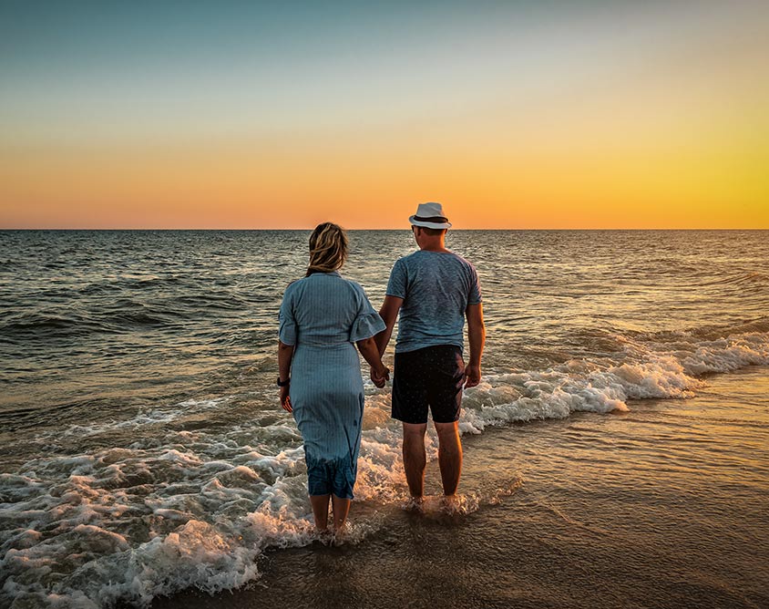 Couple paddling and looking out to see at sunset